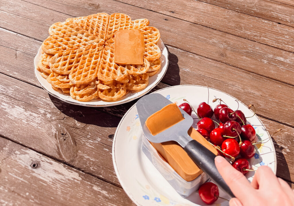 slicing Norwegian brown cheese to put on waffles