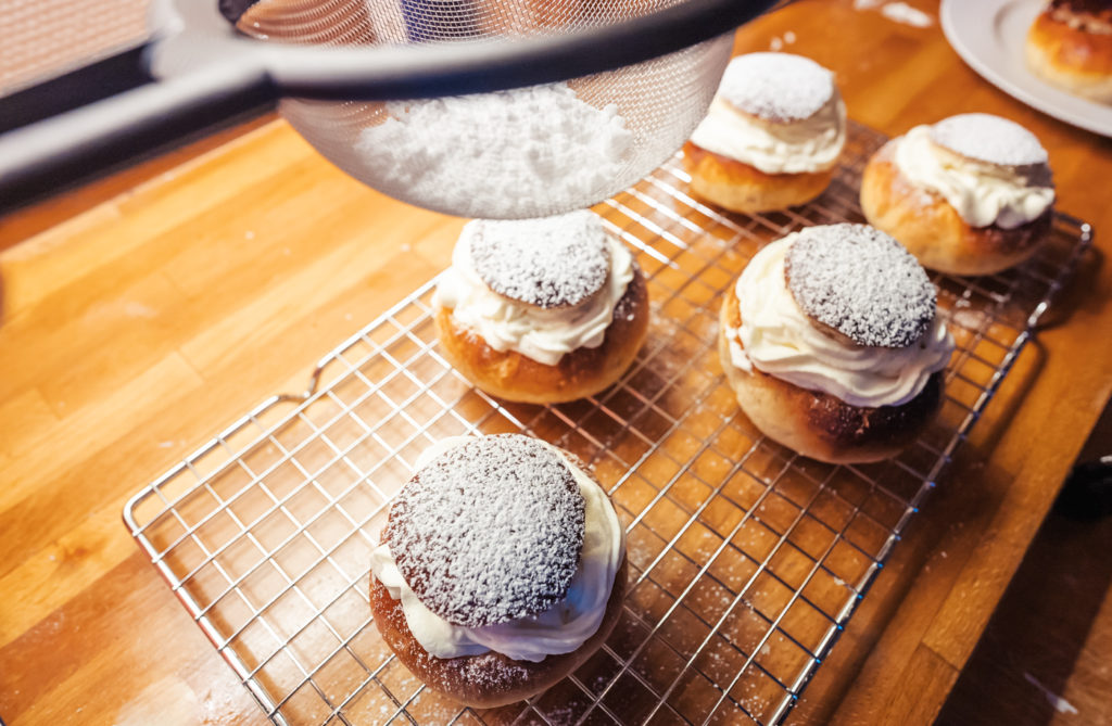 topping semlor with powdered sugar