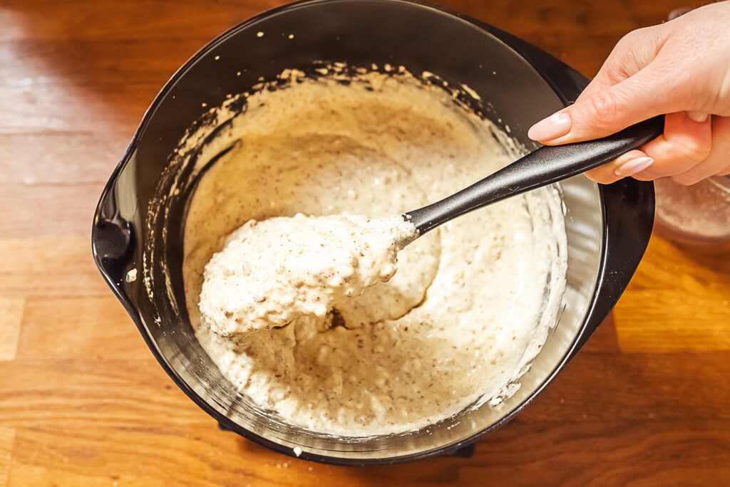 folding almonds into whipped eggs for suksessterte