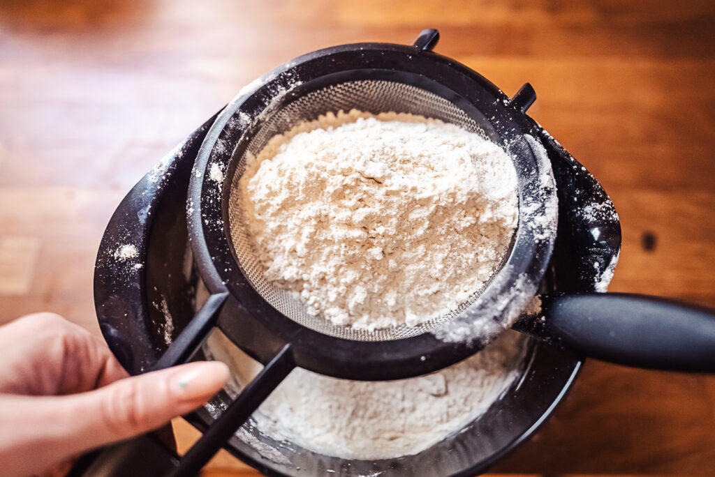 sifting flour over cake batter