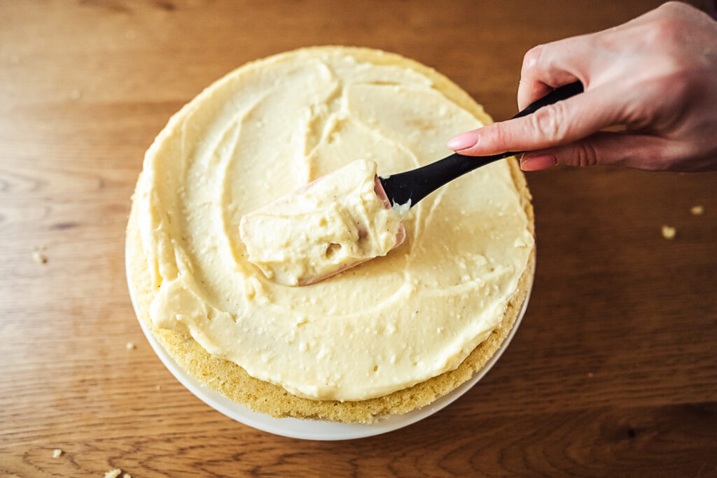 spreading vanilla cream on lagkage layer cake base