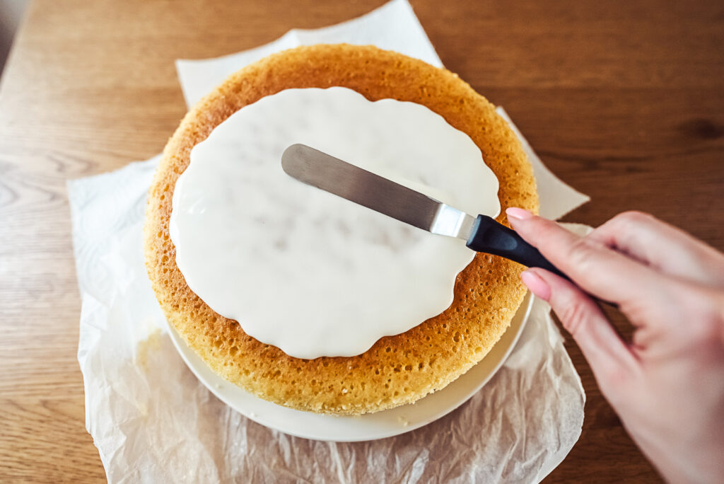 spreading glaze on layer cake top
