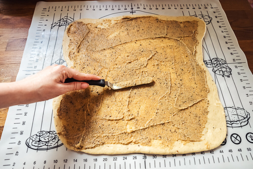 spreading cardamom butter filling across dough