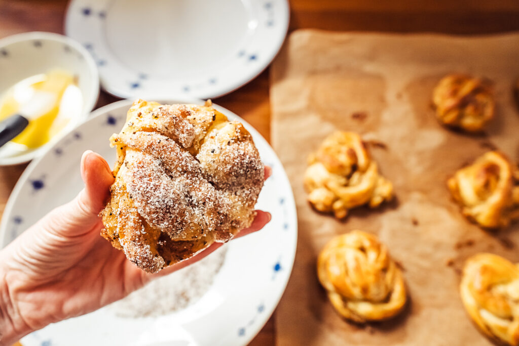 dipping kardemummabullar in cardamom sugar