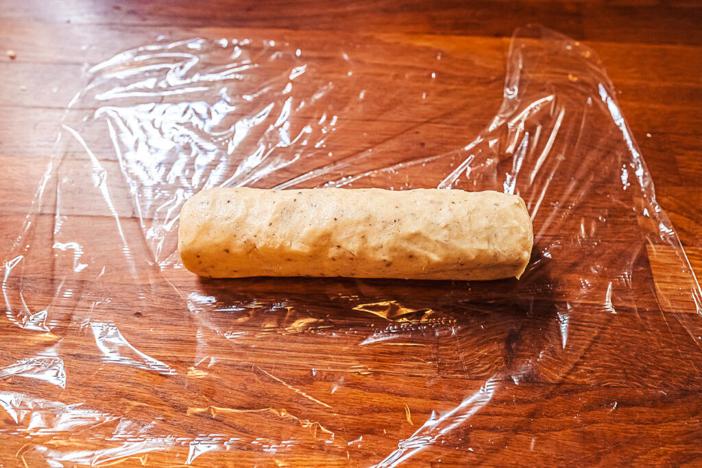 rolling cardamom cookie dough into a sausage