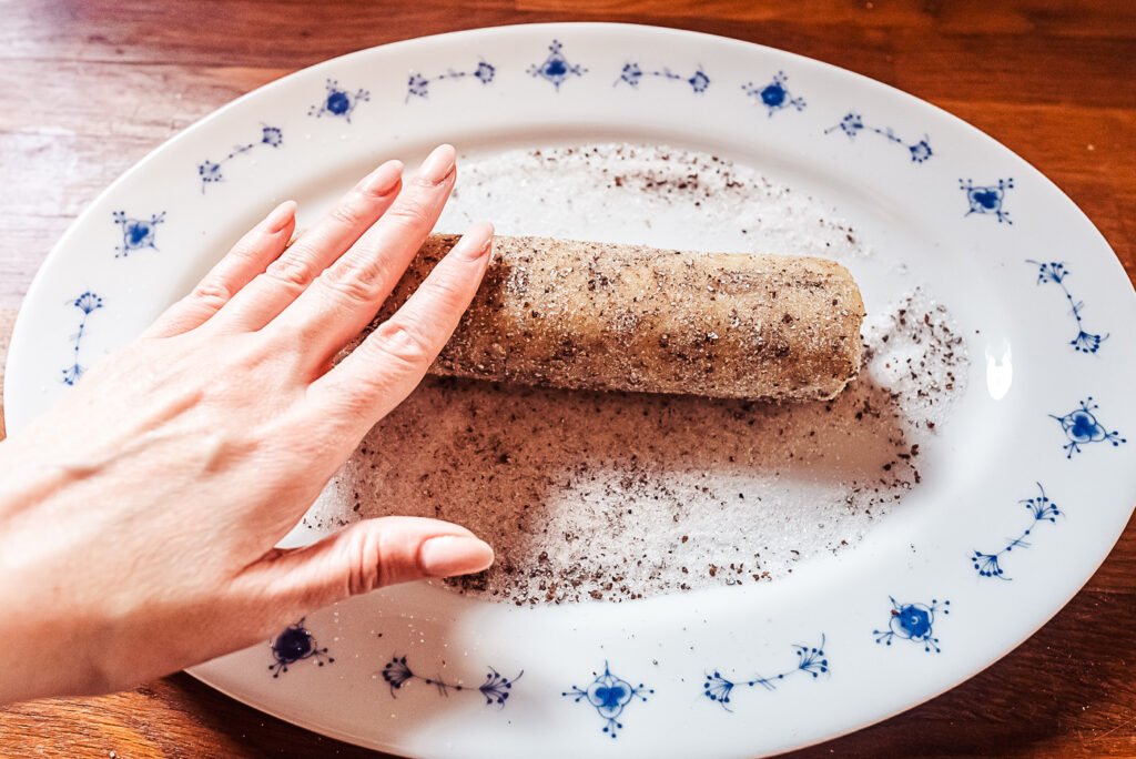 rolling cardamom cookie dough in cardamom and sugar