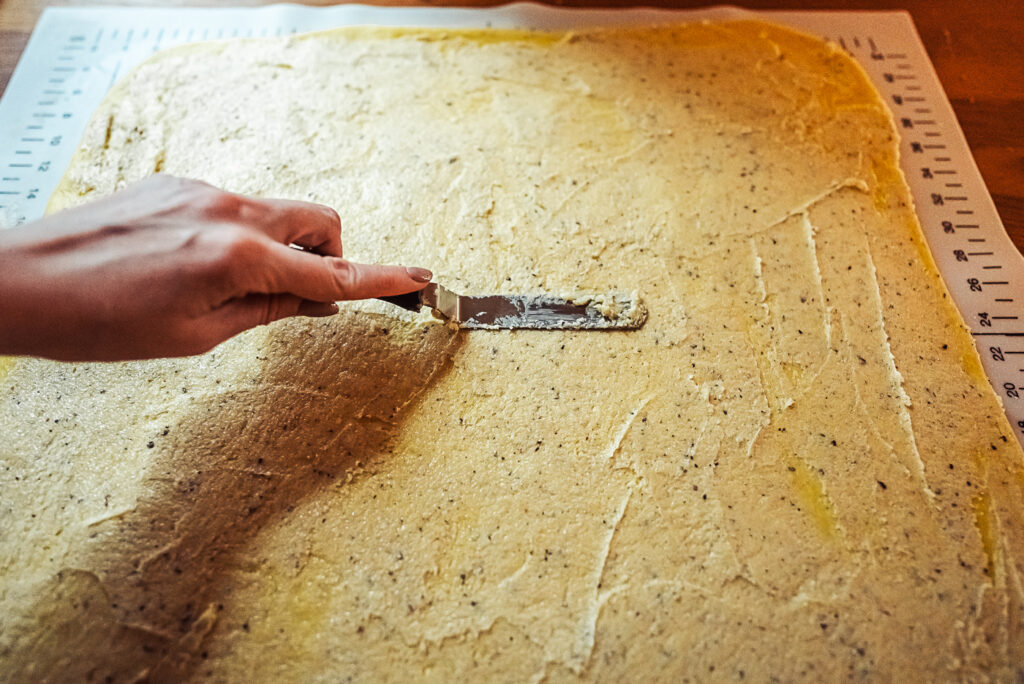 spreading cardamom butter on dough