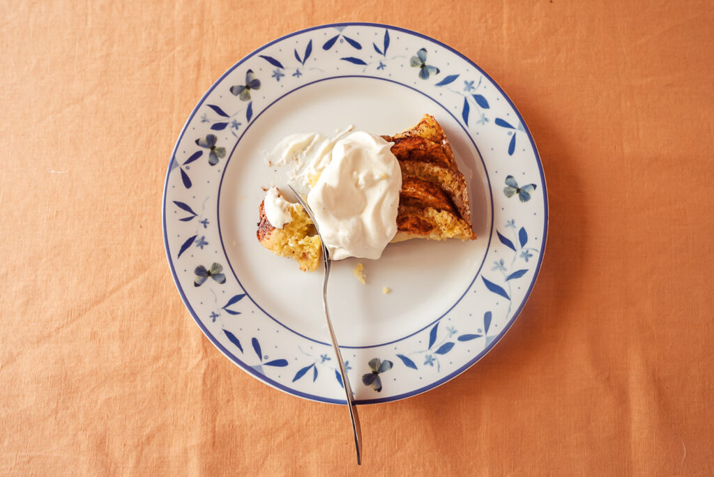 plate with a piece of Norwegian apple cake with whipped cream