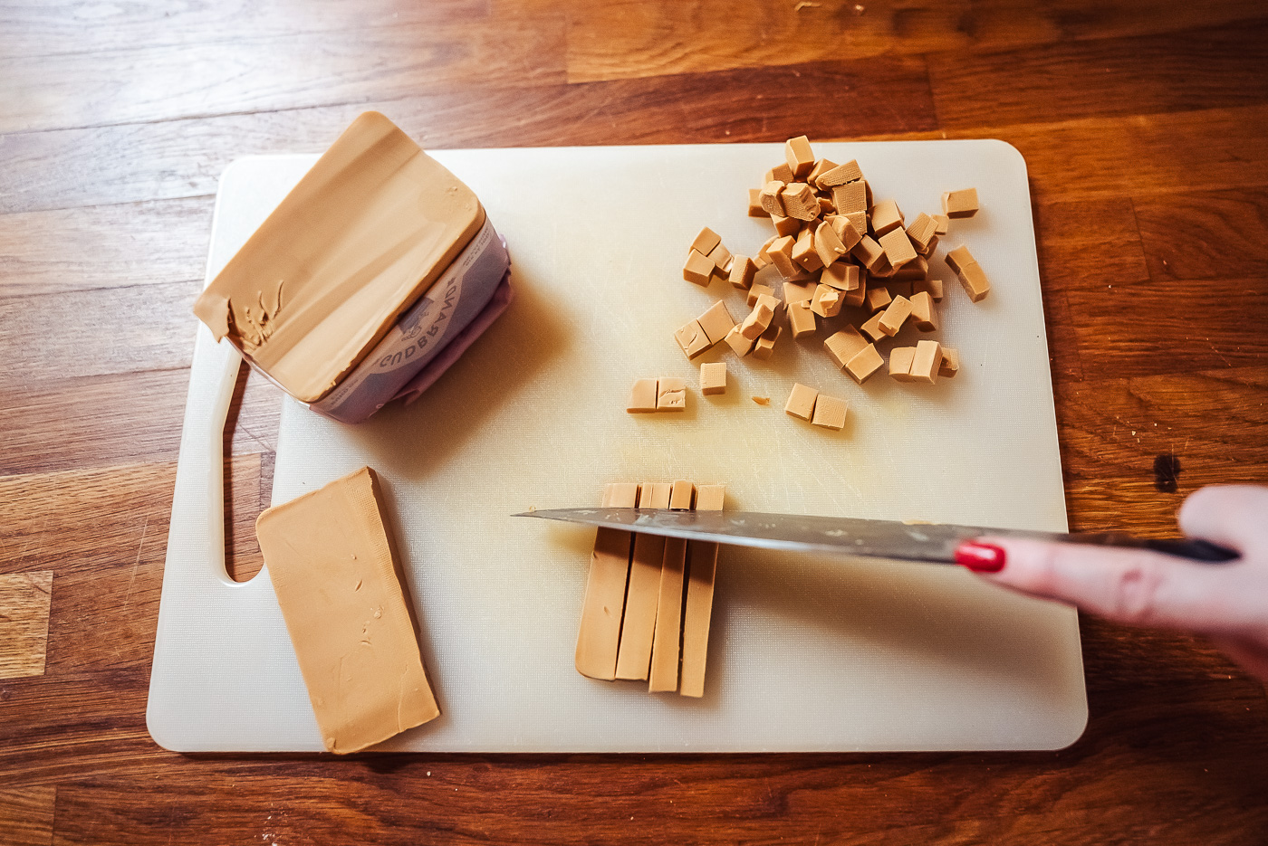 cutting brown cheese into cubes