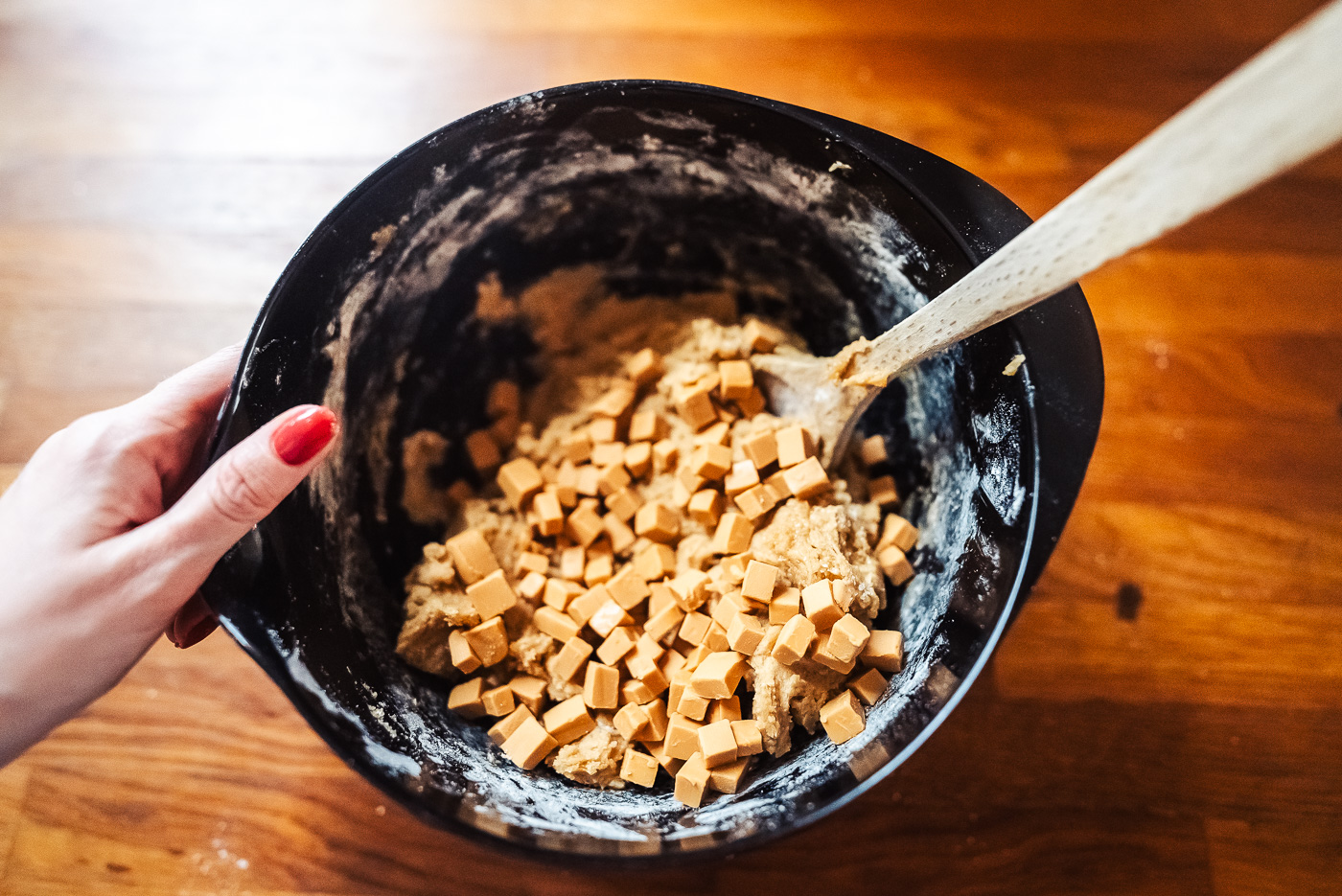 Mixing brown cheese cubes into cookie dough