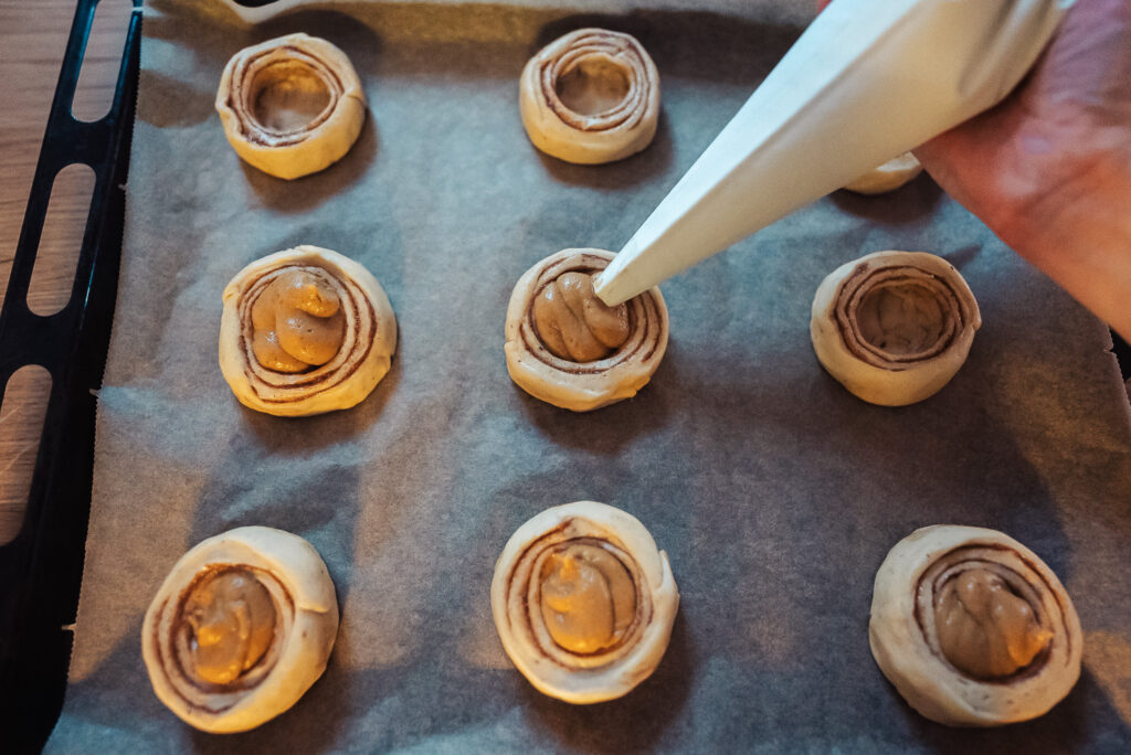 piping pumpkin pie filling into cinnamon rolls