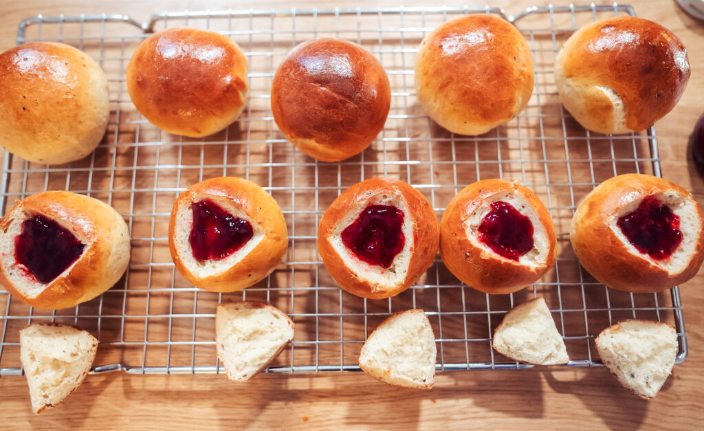 Norwegian fastelavnsboller filled with jam on wire rack