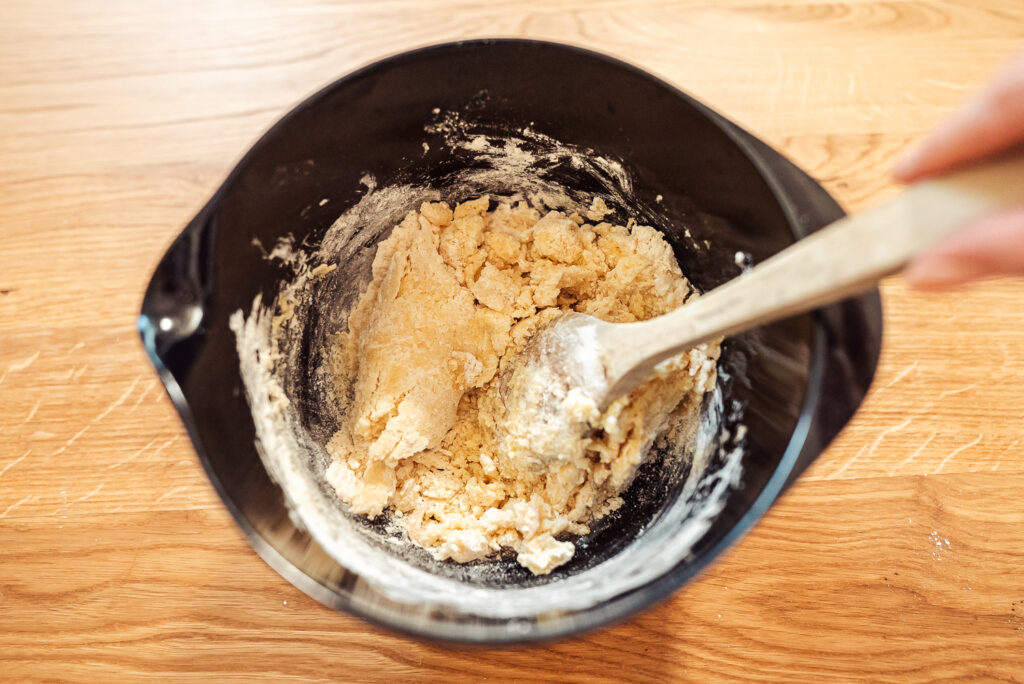 mixing together almond cookie dough in a black bowl
